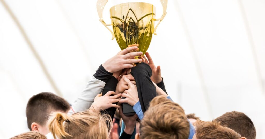 優勝カップを抱えている人々の写真