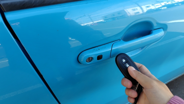車のカギをスマートキーで開けようとしているところ