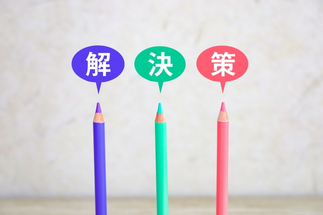 青、緑、赤の色鉛筆と「解決策」の文字