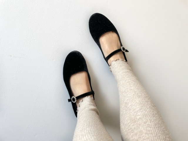黒いベロアパンプスを履いている女性の足元