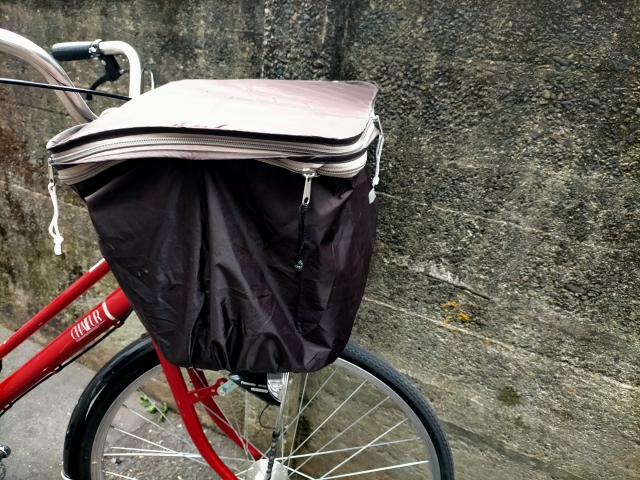 黒と白の雨カバーを付けた自転車